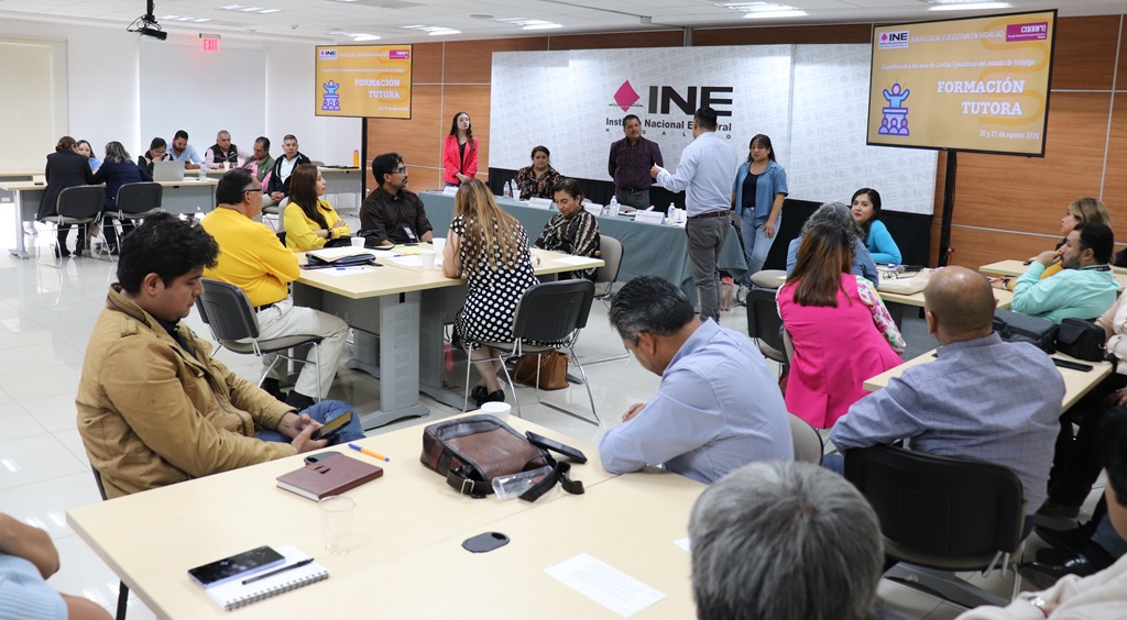 varias personas en un salón, en grupos de cinco