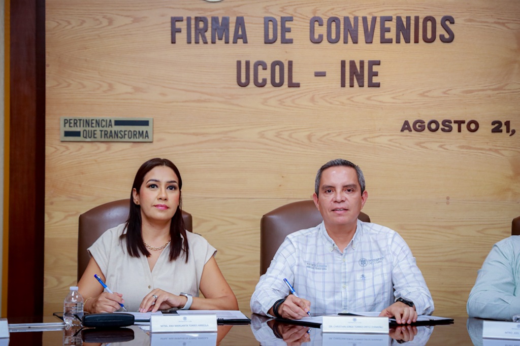 una mujer y un hombre sentados con documentos en la mesa