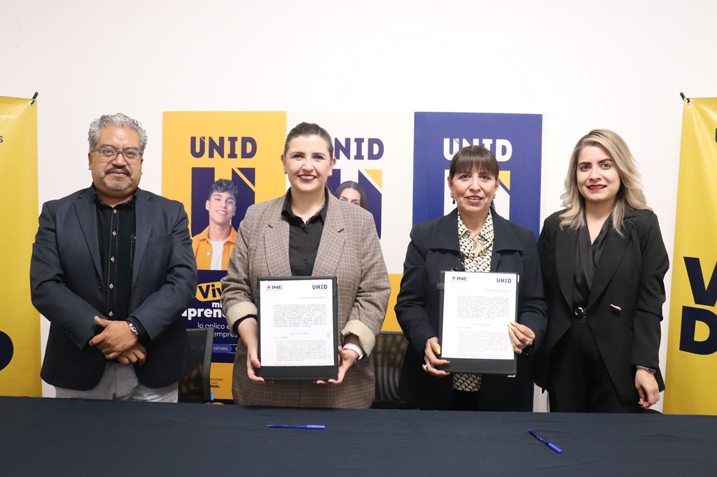 tres mujeres, dos sostienen un documentos en la mano y un hombre de pie para la foto oficial