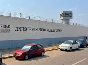 muro alto blanco con azul con rejas y en la parte superior una torre de vigilancia