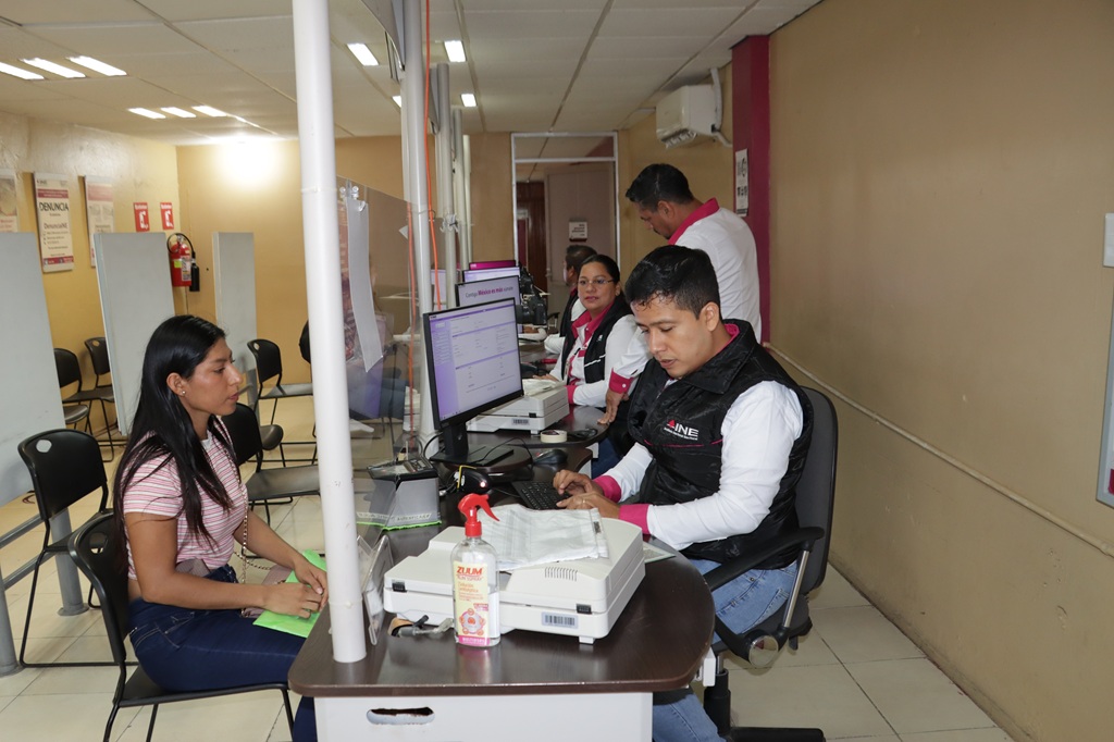 Una persona funcionaria del INE atendiendo a una joven