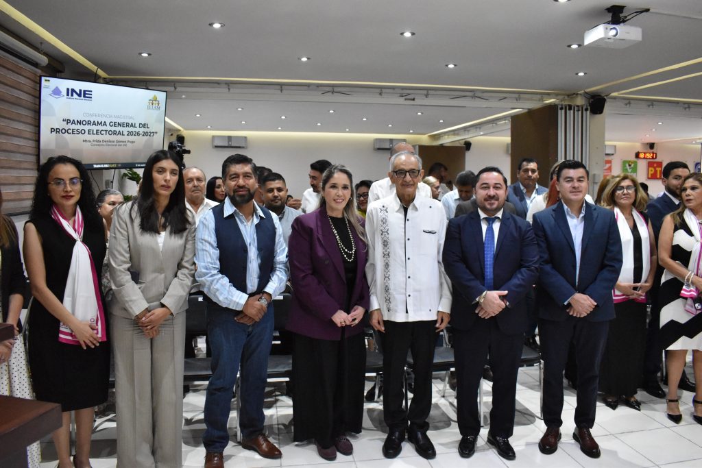 Personas participantes paradas en el salón posando para la foto.