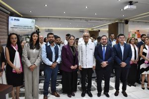 Personas participantes paradas en el salón posando para la foto.