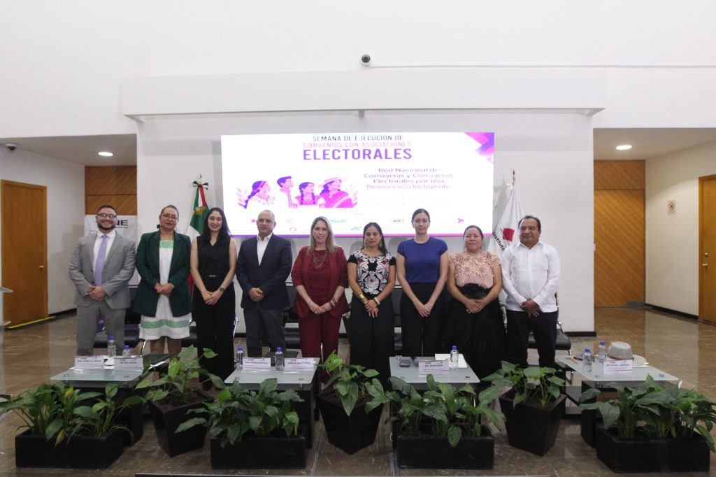 Personas participantes paradas en el estrado posando para la foto.