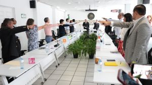 varias personas de pie con el brazo derecho extendido al frente