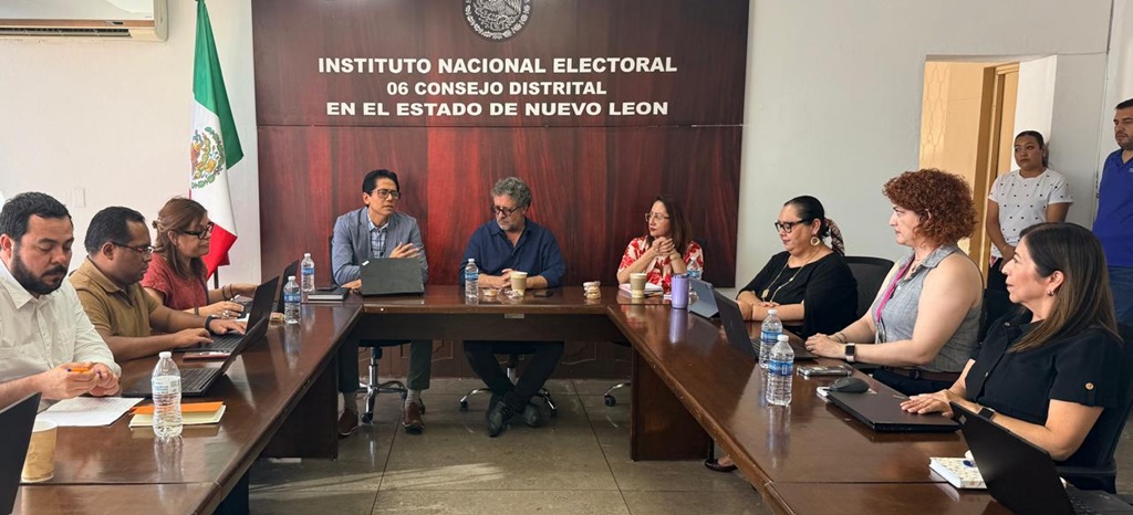 varias personas sentadas alrededor de una mesa rectangular