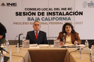 un hombre y una mujer sentados frente a una mesa con micrófonos