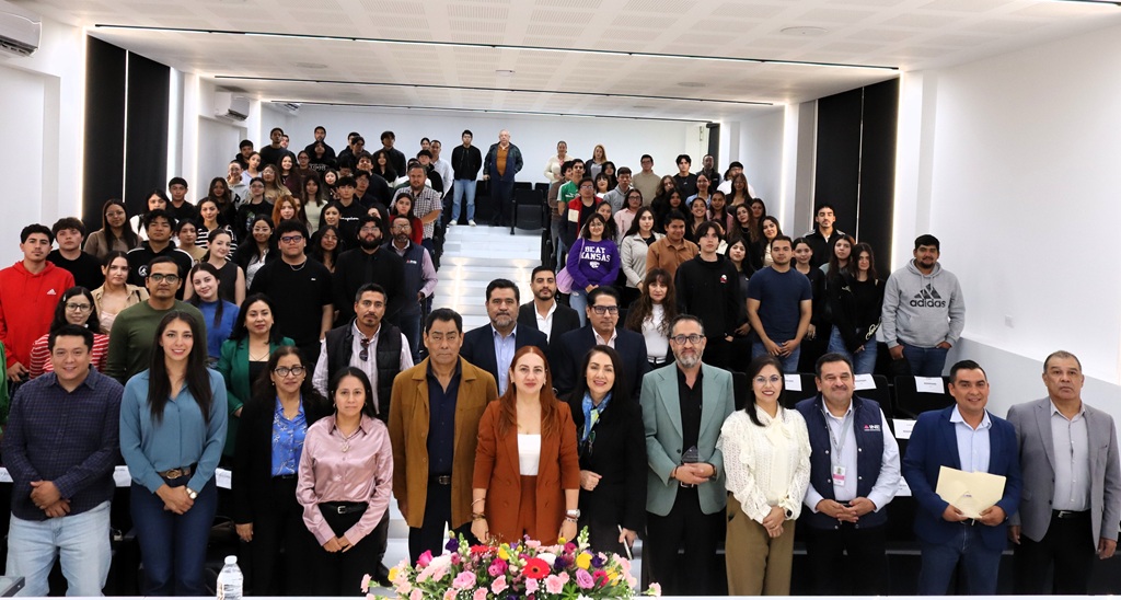 personas de pie en un auditorio posando para la fotografía