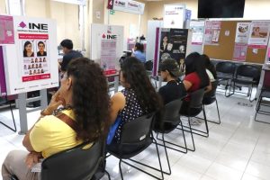 cinco personas sentadas en las salas de los módulos de atención ciudadana del INE