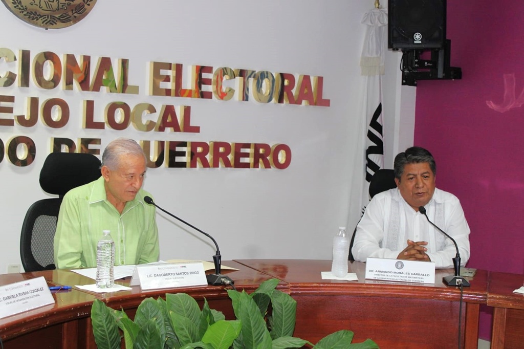 un hombre adulyo mayor cabello cano sentado a un lado de un hombre camisa blanca