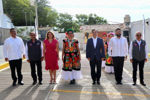 cinco hombres y dos mujeres de pie, una de ellas viste un traje tradicional