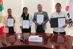 dos mujeres y dos hombres de pie, cada persona sostiene un documento