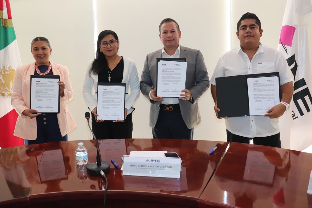 dos mujeres y dos hombres de pie, cada persona sostiene un documento