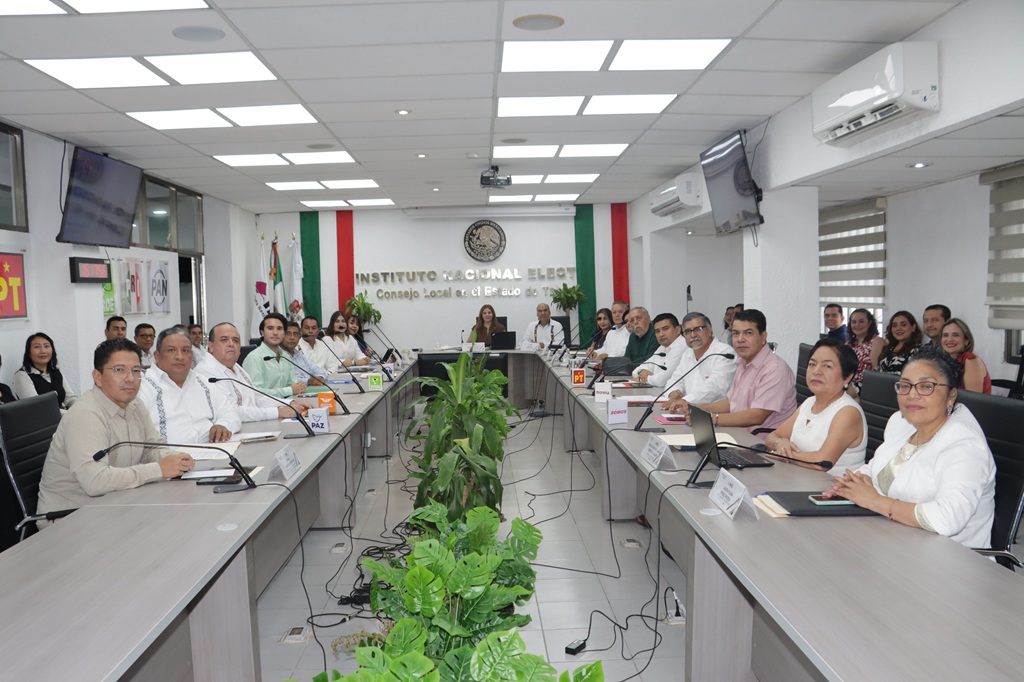 varias personas sentadas en un salón blanco posando para la fotografía oficial