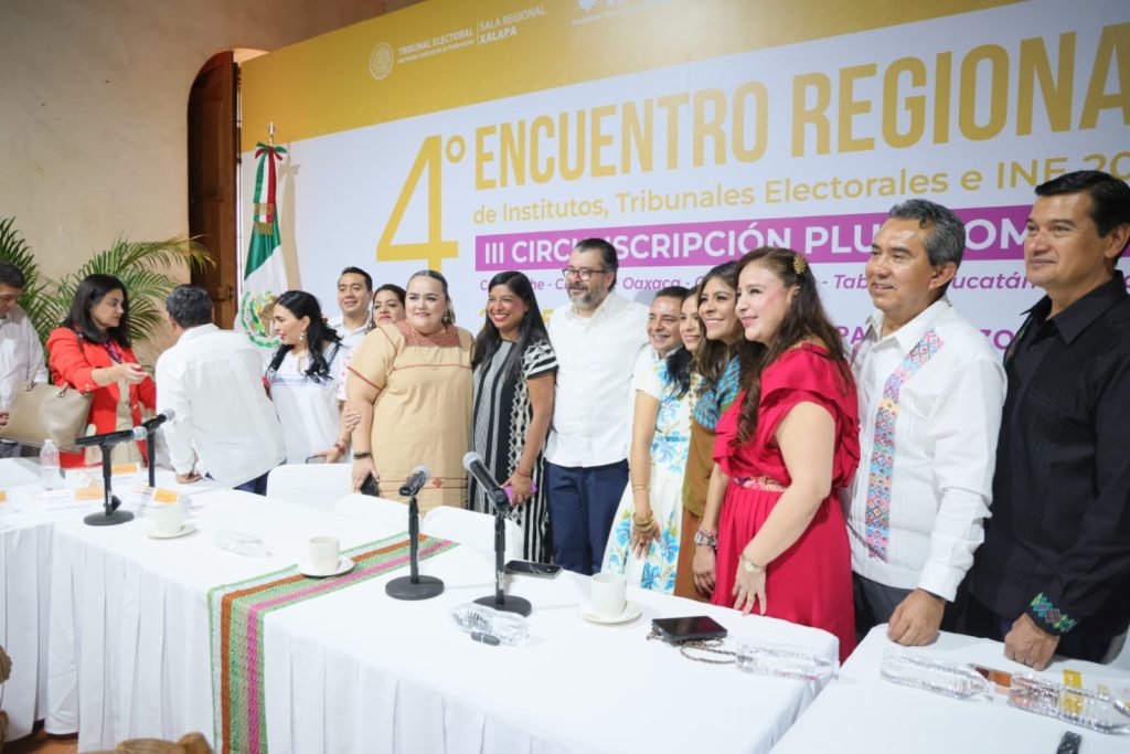 Personas participantes paradas en el salón posando para la foto oficial.