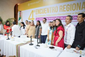 Personas participantes paradas en el salón posando para la foto oficial.