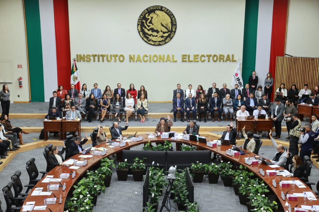 Personas Consejeras Electorales y representantes de partidos políticos sentados en el salón de sesiones del instituto.
