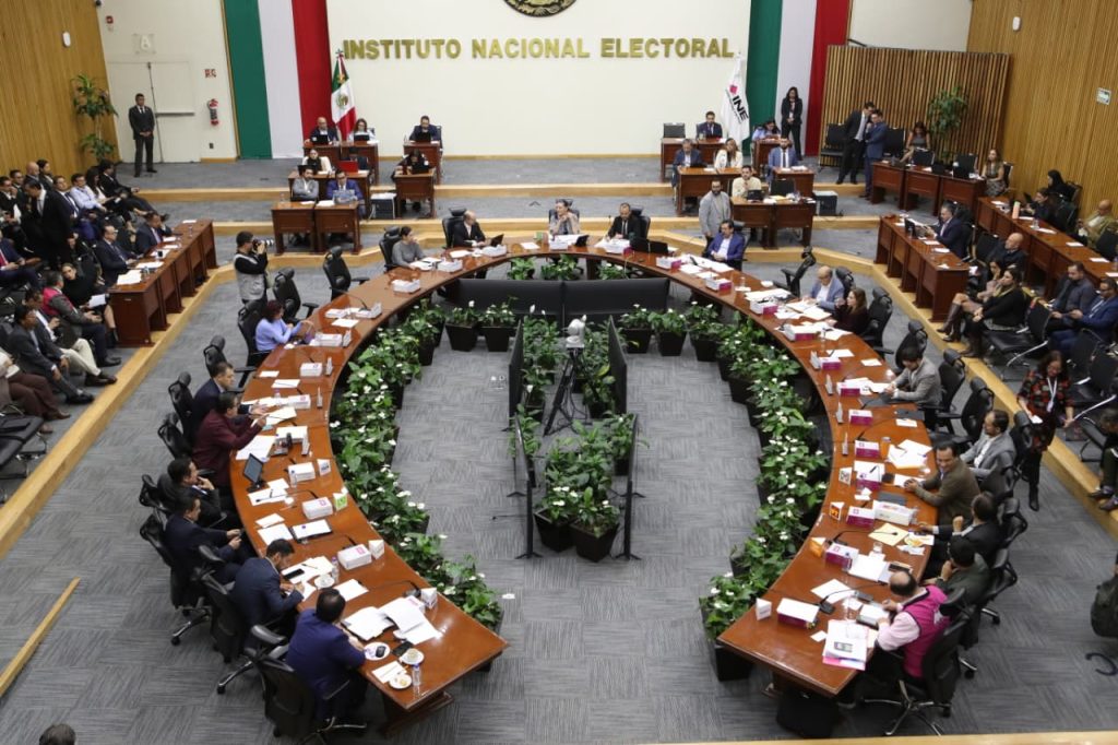 Personas Consejeras Electorales y representantes de partidos políticos sentados en el salón de sesiones del instituto.