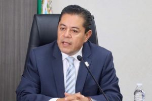 hombre sentado hablando frente a un micrófono