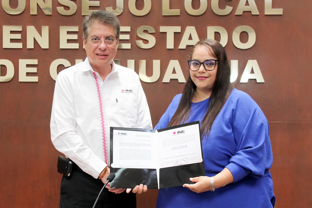 una mujer y un hombre sostienen un diploma