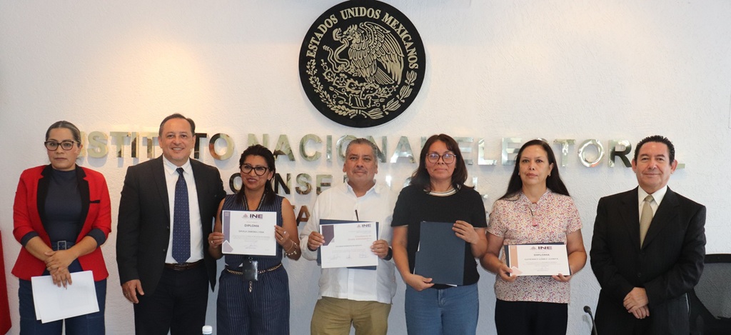 siete personas de posando con diplomas