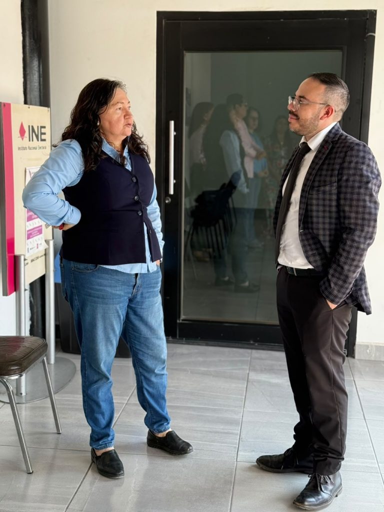 una mujer y un hombre de pie platicando