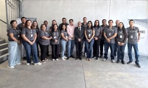 veinte personas de pie vestidas de gris posando para la fotografía