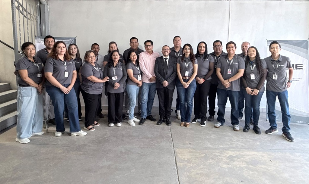 veinte personas de pie vestidas de gris posando para la fotografía