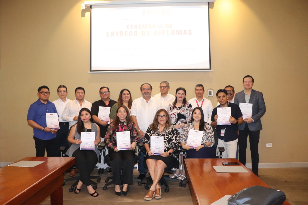 dieciséis personas sosteniendo sus diplomas