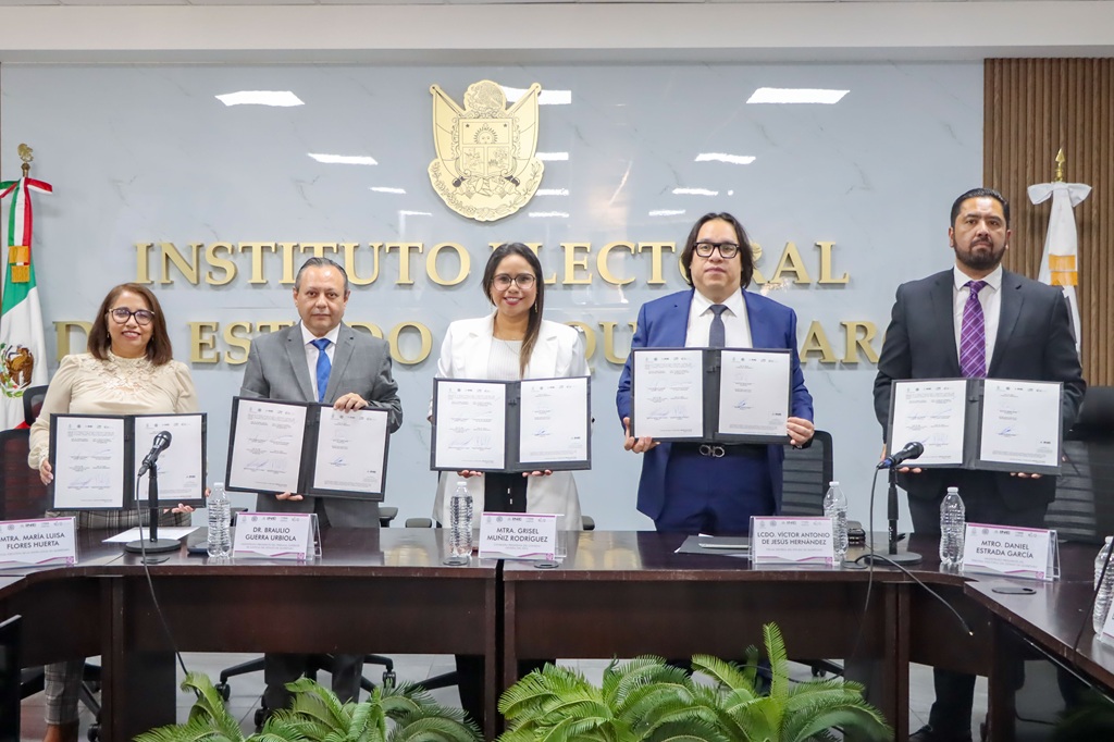 dos mujeres y tres hombres de pie posando para la foto, cada persona sostiene un documento