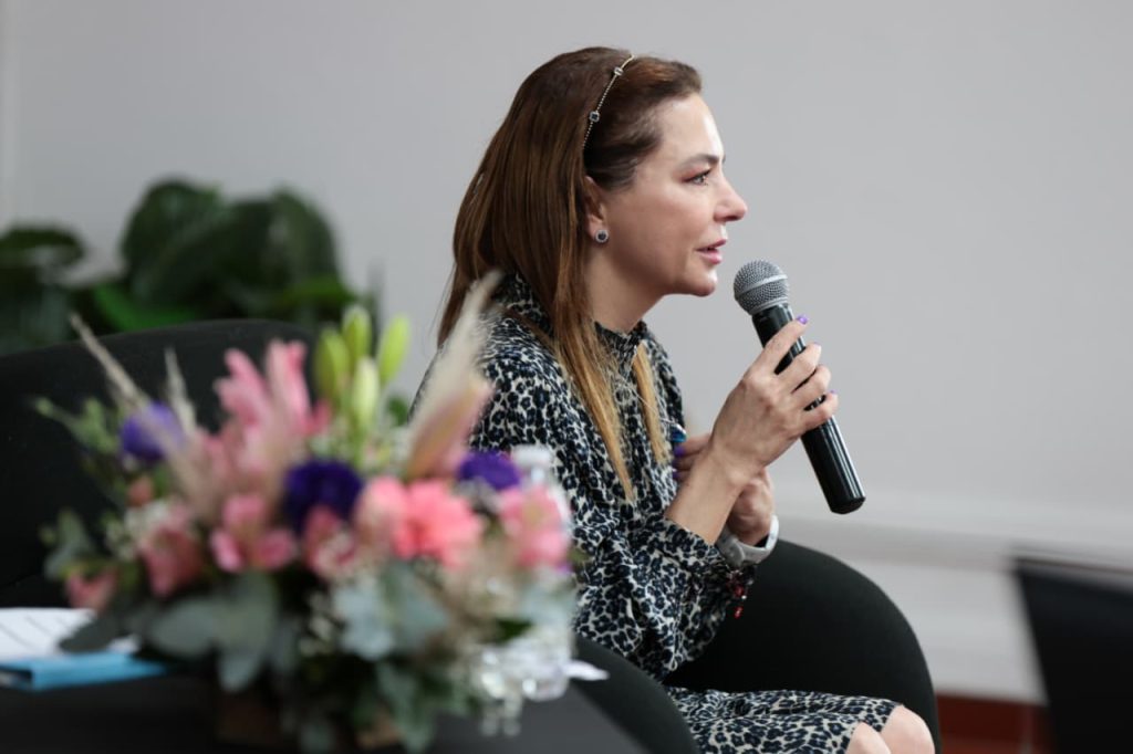 Mujer con microfono en mano en conferencia