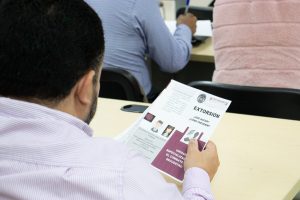 hombre sentado viendo una hoja que dice EXTORSIÓN